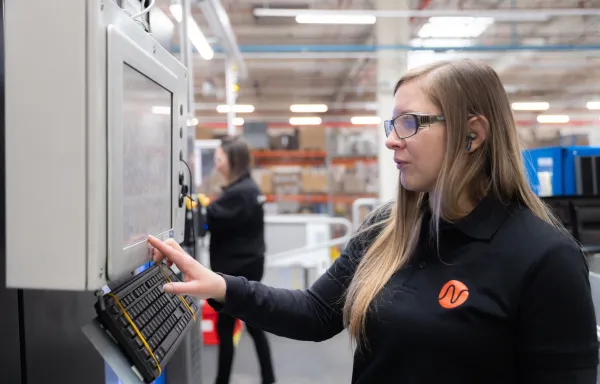 Technicienne en métrologie et mesures physiques utilisant un écran de contrôle dans un atelier industriel