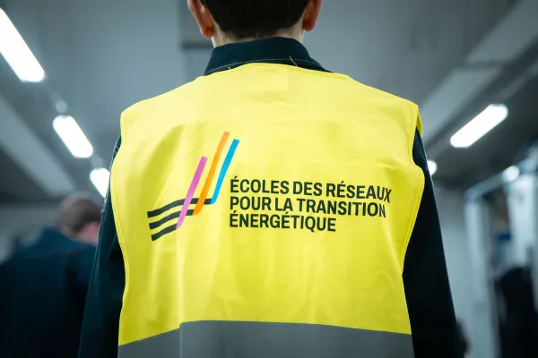 Vue de dos d’une personne portant un gilet Écoles des Réseaux pour la Transition Énergétique