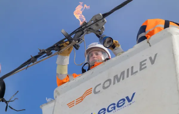 Monteur de réseaux électriques intervenant sur des câbles électriques depuis une nacelle